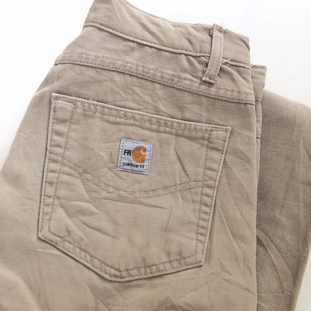 Säljer ett par beigea Carhartt Workpants, köpta second hand. Oklar storlek, men känns som (W30) Avklippta i benen! Lite frakt tillkommer☀️. Jeans & Byxor.
