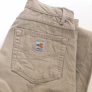 Carhartt work pants - Säljer ett par beigea Carhartt Workpants, köpta second hand. Oklar storlek, men känns som (W30) Avklippta i benen! Lite frakt tillkommer☀️