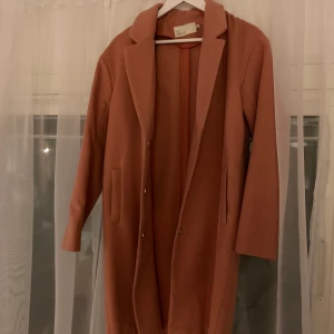 Aprikosrosa kappa - En kappa som aldrig använts! Mer rosa än vad den ser ut på bilden, men en fin aprikosrosa färg! Från Nelly, storlek 40❤️