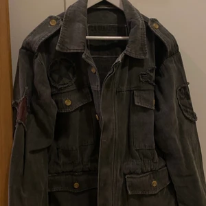 Militärjacka - Jättefin vår jacka köpt från de spanska design märket la jabalcuza. Jackan är i fint tjockt matrial med coola tryck. Går även att dra åt i midjan. Jackan är använd 1 gång. Orginal pris på jackan var 2600 men säljer för 700kr.