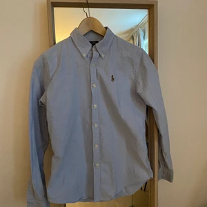 Skjorta Ralph Lauren  - Säljer en ljusblå skjorta i slim fit från Ralph Lauren, storlek UK6/EU34/XS. Enbart använd vid tre tillfällen, därav i nyskick. 