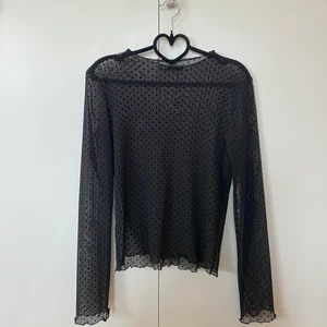 Prickig, transparent meshtop - Supersöt meshtop från Zara i storlek S. Den är svart med små prickar och har en vågig fåll. Tröjan är helt oanvänd då jag inte hittat tillfälle att bära den. 