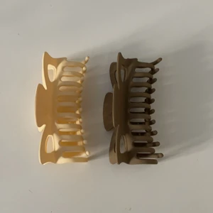 Hårklämmor - Två hårklämmor, en brun och en beige från shein. Lite för stora för mitt hår. 30kr för båda.