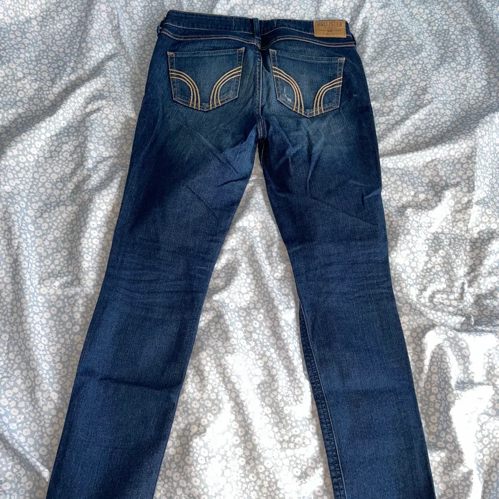 Mörkblå Hollister jeans med slitningar, storlek 25/31, i fint skick. . Jeans & Byxor.