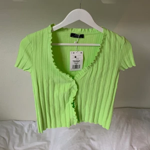 Ljusgrön topp! - Ljusgrön topp från Bershka med knäppning framtill (går alltså att ha öppen som kofta om man skulle vilja det). Helt oanvänd med prislapp kvar! Är relativt lite i storlek mer som en xs-s. 
