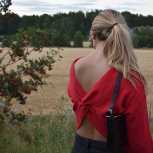 Röd stickad tröja - Jättefin röd stickad tröja med knytning bak. Knappt använd! Skulle säga att den passar strlk S men även på mig som är en M. Vi står för frakt! 