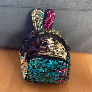 Fancy liten paljett-ryggsäck  -  Paljett ryggsäck med ett större fack och ett mindre fack, kommer från Lindex. Väldigt bra skick aldrig använd lappen är kvar. 