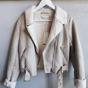 Jättefin höstjacka  - En jättefin beige höstjacka i fejkmocka från Nelly Trend. Den har mjuk vaddering på insidan och ett skärp i midjan. Helt oanvänd med prislappen kvar! 200kr + frakt 
