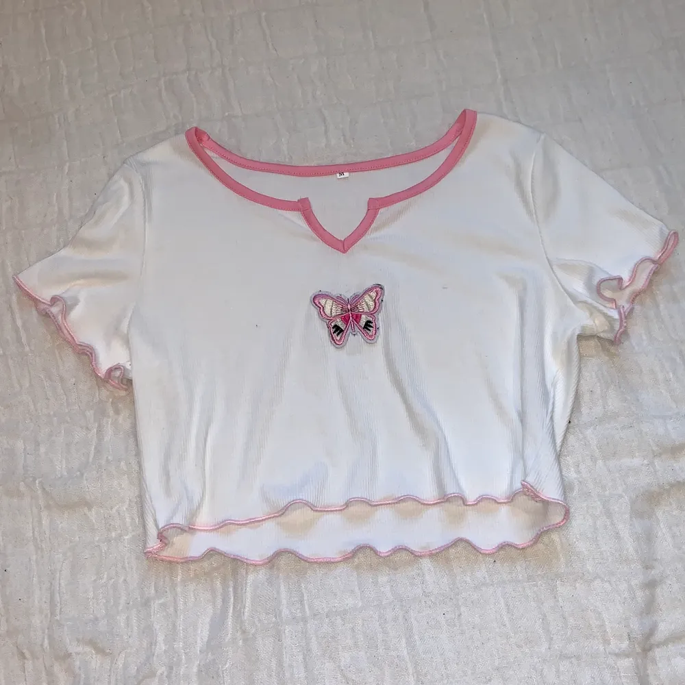 Cute white crop top with pink detailing and a butterfly patch // New condition // Buyer pays for shipping (even though it says frees shipping in the post) . T-shirts.