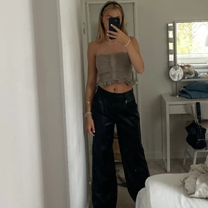 Kostymbyxor i skinnimitation - Svarta ”skinn” kostymbyxor, de har en oversized passform och långa i benen, jag är 172 cm. Storlek 34/36. Från NAKD, nypris 579kr. Bra skick!