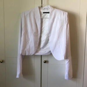 Vit blus - Fin vit blus i härligt material med axelvaddar! Använd ett fåtal gånger, säljer då den tyvärr är för liten. Köparen står för frakten.