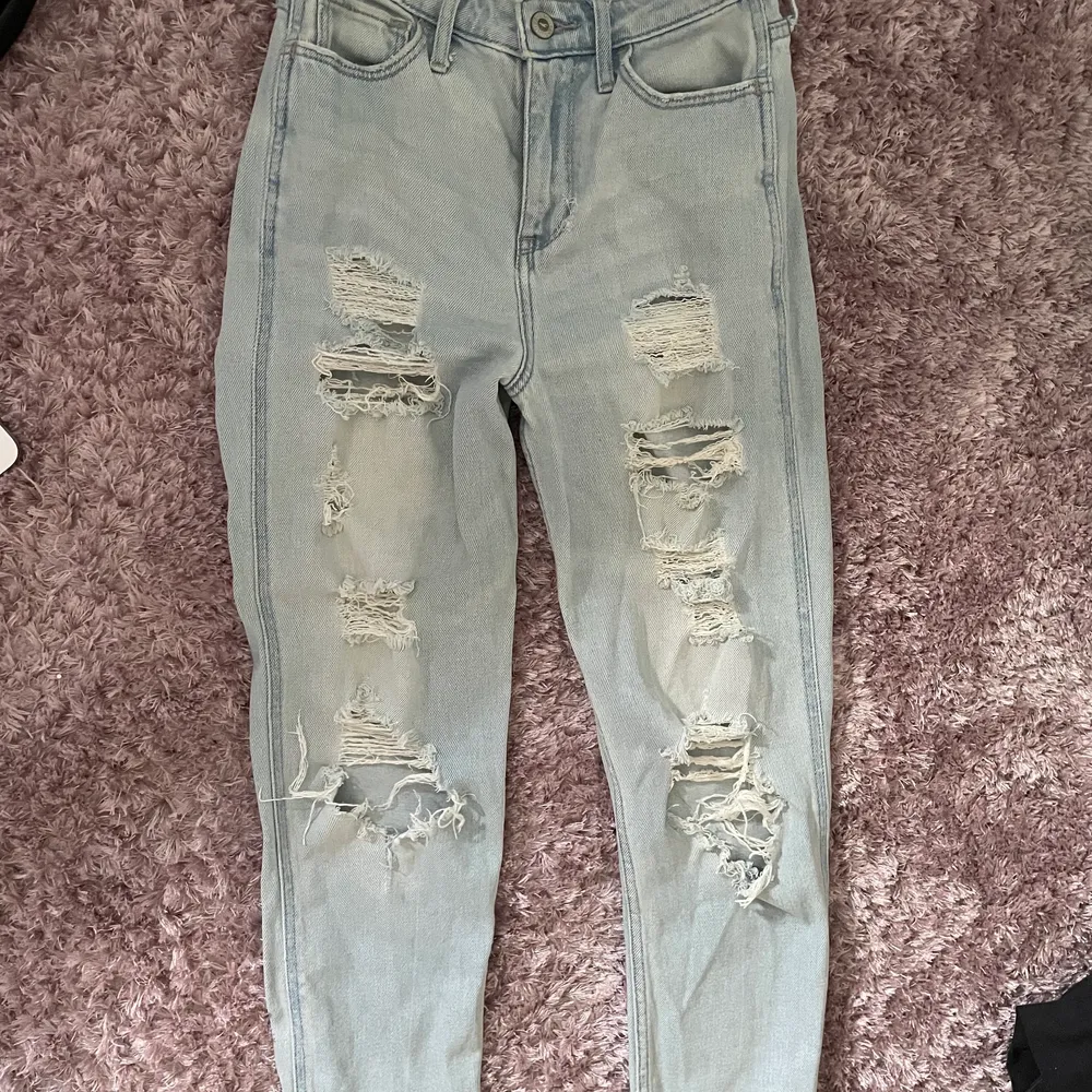 Ett par ljusblåa jeans från Hollister med hål på framsidan. Jättefin passform! Bra skick! W24 L 27, passar mellan XS/S enligt mig. . Jeans & Byxor.