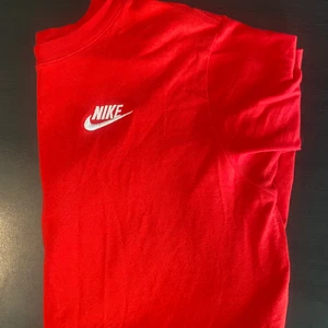 Röd Nike tshirt - Säljer denna fina röda Nike tshirt som endast är använd 2 gånger. Den är i barnstolek XL och sitter fint och oversized påminner som är XS/S