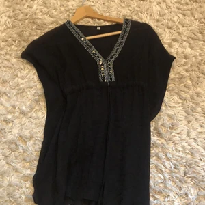 Svart strand klänning/blus - Svart blus/klänning ,bra kvalitet,till för o ha den över badkläderna,storlek xxs,säljer den för att den inte är min still längre(köpare står för frakt)