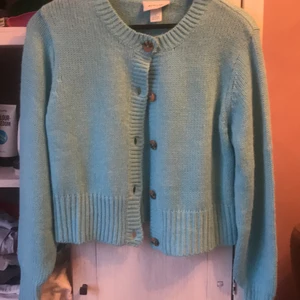 Monkl kofta - Ljus blå kofta stickad. Den ör kort och slutar ungefär vid midjan. Den är storlek L men är väldigt liten.