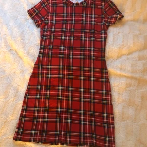 Röd rutig klänning från H&M - Röd rutig klänning med gult/blått/vitt i det rutiga mönstret. Strl s men väldigt tajt model. 