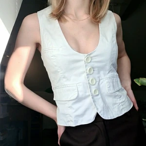 Vit kostymväst  - Säljer denna kostymvästen från veromoda då den är för stor för mig (hårklämma där bak för att visa hur den ser ut på). Är vanligtvis en 34/36 men denna är förstor då den är stl 38. Djup urringning. Fint skick. Går att justera stl till viss del då den knyts där bak med ett snöre.