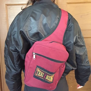 Väska  - Insta: biba__boi, gmail: bibaboikarin@gmail.com Super snygg väska som man har snett över en axeln den är mörkröd med ett märke där back där det står thai boxing som jag skälv har sytt på. 