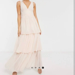 Balklänning - Jättefin puderrosa balklänning från Little Mistress. Köpt på asos, nypris 1086 kr men är slutsåld! Strl 36. Plisserad i volangerna. Endast använd en gång så i bra skick. Köparen står för frakten.