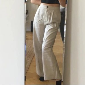Asos beiga linnebyxor - strl 38 - Säljer skönaste byxorna pga har ett till par liknande! Beiga linnebyxor från Asos med vida ben och hög midja. Oanvända - lappen kvar!! Perfekt längd på mig 175cm <3 Fraktkostnad tillkommer!