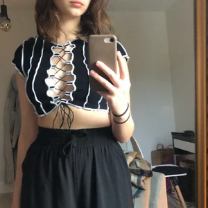 croptop från hm - En croptop från HM som har öppning i mitten, stänger genom snörning, ganska kort. Man kan ha BH på sig, men de syns inte igenom om man inte har de:) Använd 1 gång. Köpte för 100 säljer för 70