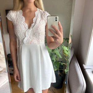 VIT KLÄNNING MED SPETS - Klänning med spets på övre framsidan, använd en gång. Superbekväm, går utmärkt att ha BH i om man vill, och bra material som gör att den inte är genomskinlig över huvud taget. Perfekt till exempelvis student eller skolavslutning! Försluts med dragkedja baktill vid ryggen.