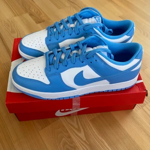 Nike Dunk Low UNC - Säljer desssa feta trendiga Dunk Low UNC. Helt DS, inte ens testade. Sjukt clean colorway, passar till allt. All OG. Skriv för frågor eller fler bilder!