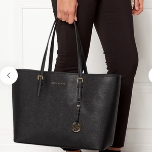 Michael kors väska (JET SET TRAVEL)  - Svart handväska från MICHAEL KORS i mycket fint skick säljes. Väskan är i skinn och har logotyp i metall (silverfärg) samt dubbla handtag upptill. Innerfack. Kan stängas med dragkedja. Längd 39cm, bredd 15cm, höjd 30cm. Perfekt storlek som rymmer en laptop och skolböcker. Nypris ca 2500-2800kr. Vid snabb affär kan priset diskuteras! Kvitto finns! 