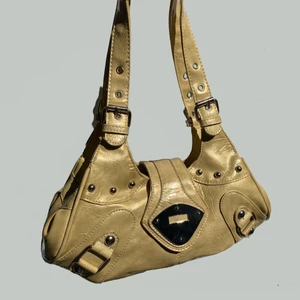 Guldig beige axelväska - Den här väskan är sjuuuk. Perfekta storleken. Finaste färgen (skulle passa så bra på en blondin) eller nån som har varma undertoner. Flera fack inuti, blixtlåsen funkar. Använd men Inga synliga defekter. Justerbara axelremmar. Jag dööör. 