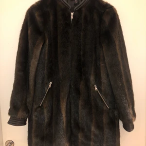 Pälsjacka - En svart/brun pälsjacka. Den är i storlek S och säljs för    300kr.