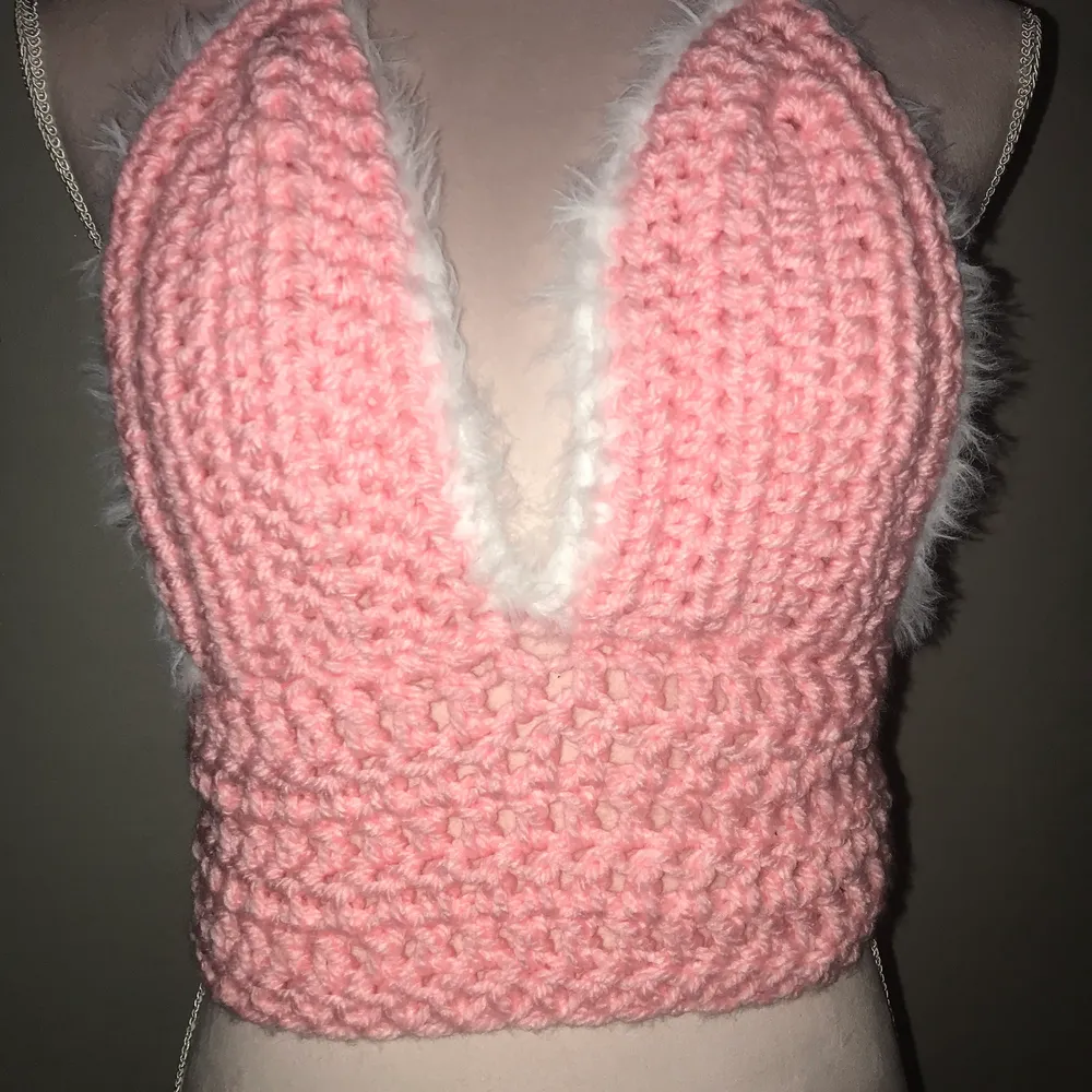 En virkad rosa bralette med fluffig vit kant. snörning i ryggen. Passar dem flesta storlekarna då stygnen är stretchiga!. Toppar.