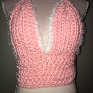 Virkad rosa bralette - En virkad rosa bralette med fluffig vit kant. snörning i ryggen. Passar dem flesta storlekarna då stygnen är stretchiga!