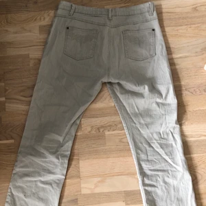 Beiga byxor i jeansimitation - Beiga byxor i stretchigt jeanstyg. Står storlek 21 i bak men skulle säga att de är i Large kanske. Sköna och snygga! Mönster på bakfickorna och textur på hela byxorna, skriv för mer detaljerade bilder eller beskrivningar! 