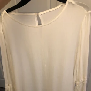 Blus - En vit blus med utsvängda armar. Storlek S