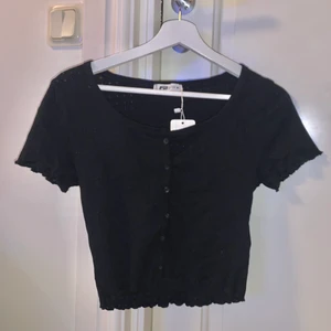 Svart topp med knappar - En jättesöt svart top med knappar. Storlek M men skulle säga att den passar mindre och större. Har aldrig använt den, lappen kvar. 💕💕