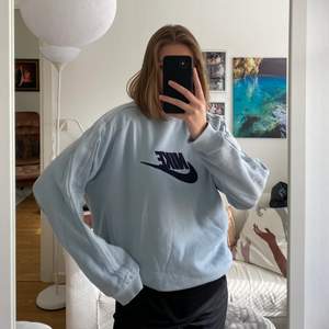 En ljusblå sweatshirt från Nike köpt på en secondhandbutik i Köpenhamn. Använd men i bra skick. Köpare står för frakt.