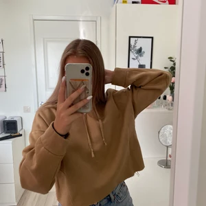 Croppad hoodie - Säljer denna brun/beiga croppade hoodie från Lager157. Den är knappt använd och i bra skick. Köparen står för frakten