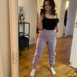 Lila trackspants från adidas - Lila trackpants från adidas i storlek XS. Har fickor på vardera sida samt snörning i midjan. Sparsamt använda.