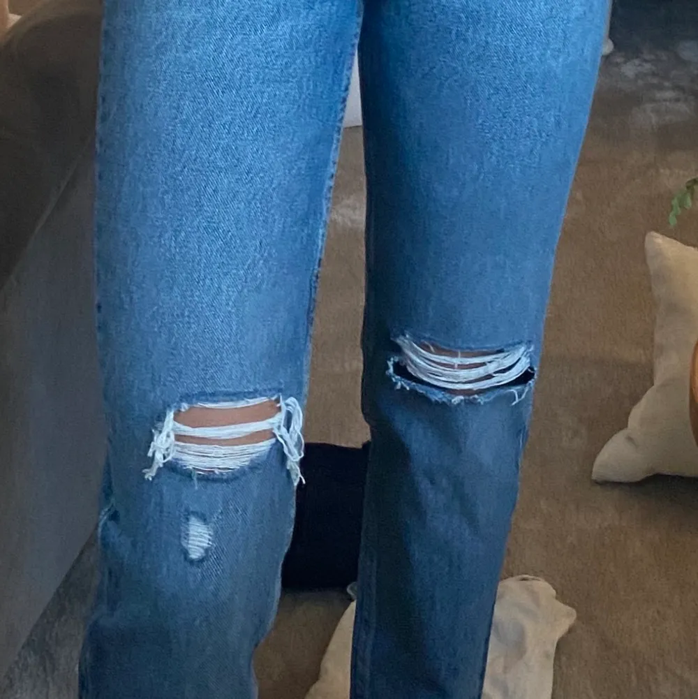 Blåa jeans från Zara med slitningar/hål på knäna, endast använda en gång då dom är för små. Jeans & Byxor.