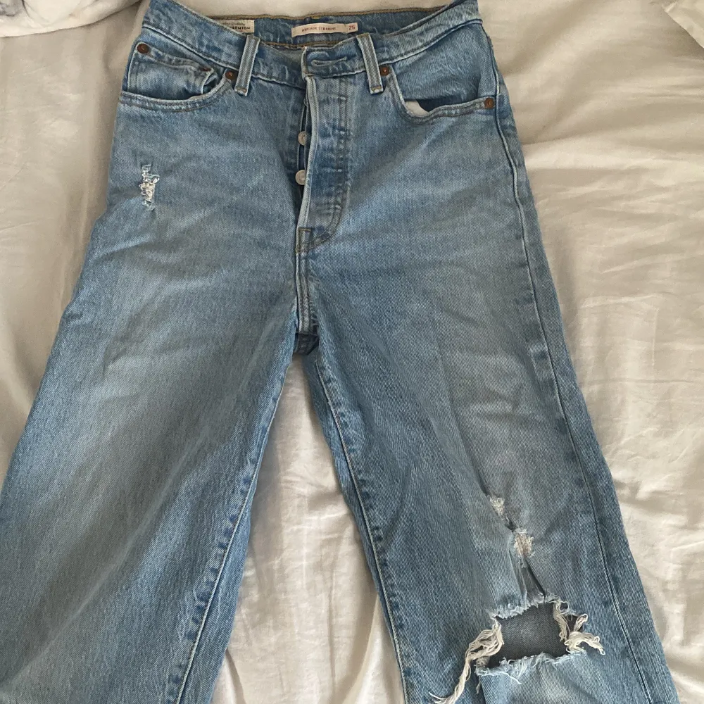 Säljer mina blå, raka Levis jeans med hål på ena knät och lite slitningar högre upp✨✨ köpta för 1290kr och säljer för 300kr, skriv för fler bilder!. Jeans & Byxor.