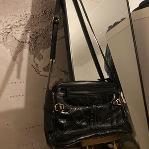 Vintageväska - Vintageväska i lädermaterial❤️‍🔥 Har en justerbar axelrem med gulddetaljer vilket gör att längden kan vara kort eller längre❤️‍🔥 Finns även andra gulddetaljer❤️‍🔥 Dragkedja och uppdelbara fack❤️‍🔥 (säljer fler väskor i min profil)