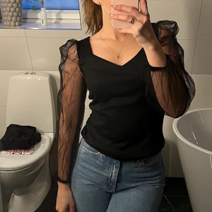 Svart blus - Svart blus med puffärm. Snålt använd och i nyskick. 