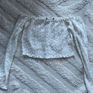 Vit croppad topp - Vit söt croppad offshoulder top, ganska genomskinlig.  Rätt säker på att jag köpt den på Bikbok för ett antal år sedan. Aldrig använd.  Lappen är avklippt men skulle säga att den är som en S-M.