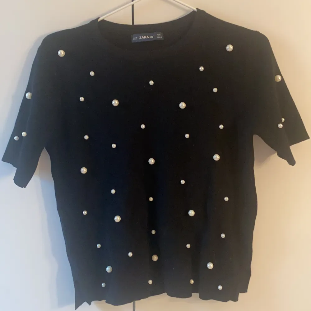 En stickad svart t-shirt med pärlor på, från zara i strl S. Den är använd men är i princip i helt nytt skick💕. T-shirts.