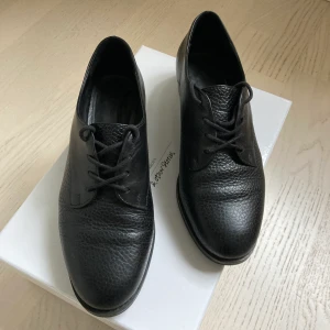 Other Stories Derby Shoes / loafes 38 - Superfina svarta läderskor från & Other Stories i Derby / Herrskomodell. Säljes i fint använt skick, finns ett märke i klacken (se bild 3).                                    Kan hämtas eller skickas, frakt 66kr spårbart med postnord (utan skokartong, med 99kr)