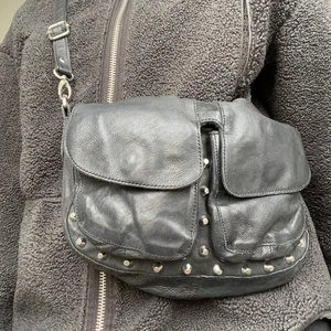 Unlimit Väska - Väska från Unlimit bags i svart skinn med silvriga nitar! Skitsnygg och i bra skick. Det finns ett längre band och ett kortare band som ni kan se på bilderna. Nypris ca 900kr