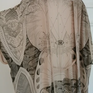 Mönstrad kimono - Tunn och luftig kimono. Transparent med beige/grå mönster. Knytband i midjan, går att dra åt eller ta bort helt. One size, rymlig. Köparen står för frakten, kan även hämtas i Malmö! 