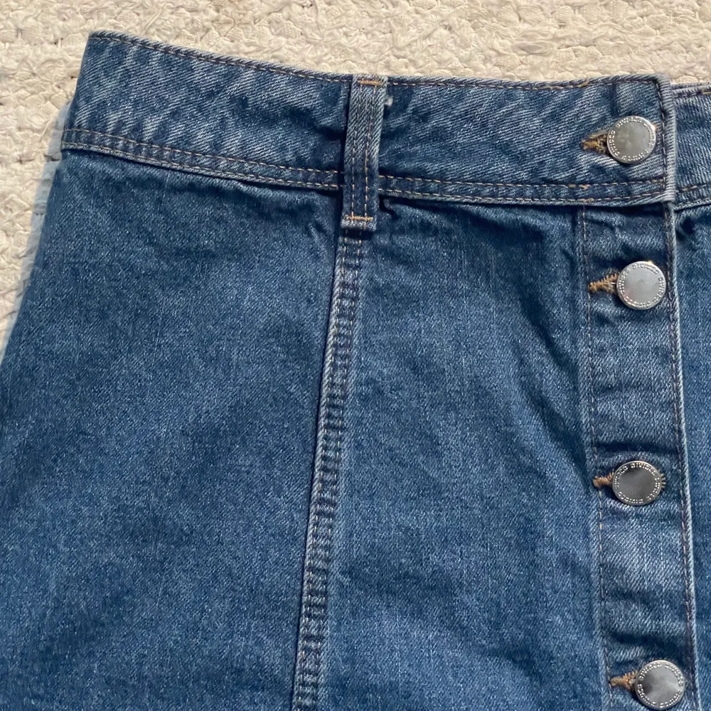 En jeanskjol med knappar framtill från H&M. Storlek:  42. Kjolar.