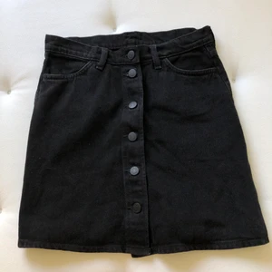 Svart jeanskjol monki - Svart jeanskjol från monki med knappar hela vägen i mitten. Strl 38/36 och knappt använd. Spårbarfrakt 66kr🧡🧡