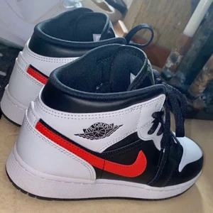 Jordan 1 Mid White Black ”Chile Red” GS - Hjälper en kompis att sälja dessa Jordan 1 Mid White Black ”Chile Red” GS. Dom köptes förra veckan och är endast använda två gånger, därmed nyskick! Äkta Jordans, köpta på Sneakershyllan i Göteborg. Kartong och kvitto finns. Kan både frakta och mötas upp.